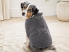 Black, white and tan dog wearing the Smoke sherpa-style fleece sweater while seated indoors