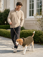 Brown-and-white dog wearing the Olive sherpa-style fleece sweater on a leash outdoors